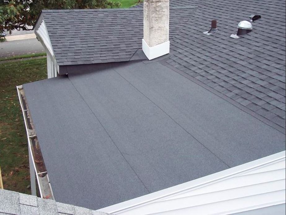 Roofing contractor stripping old shingles on a Greater Boston home