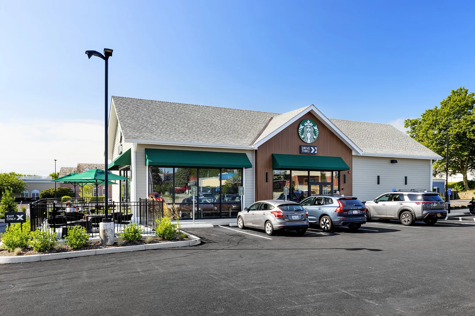 Single-story commercial building with an asphalt shingle roof, lap siding and green awnings